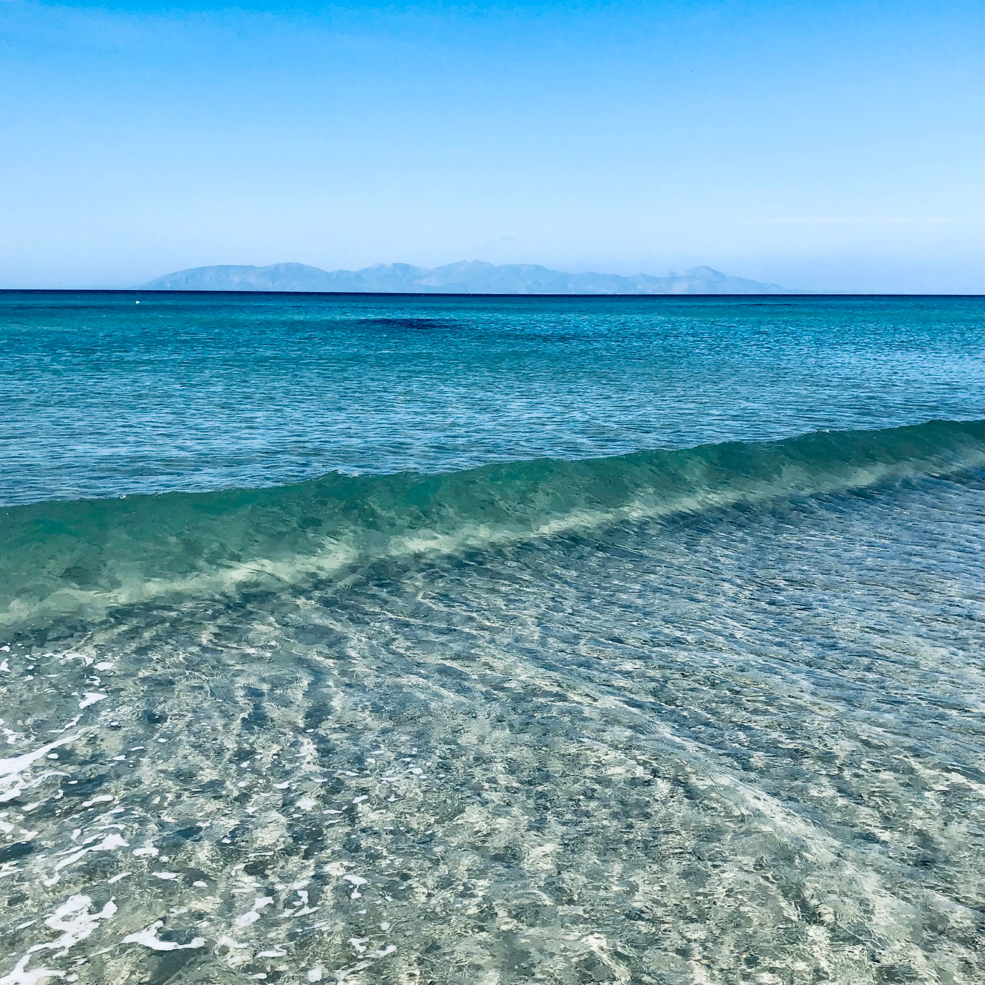 Ruhiges, klares Meer mit Blick auf die Berge – Kos